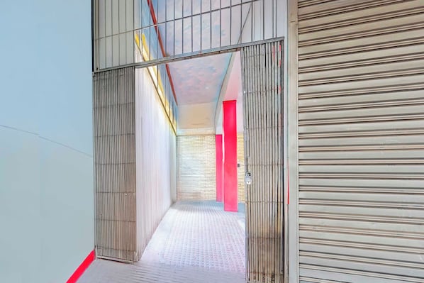 A corridor with a patterned floor, metal railings, and a red pillar. - Collection O Dighori Nagpur (Nagpur)