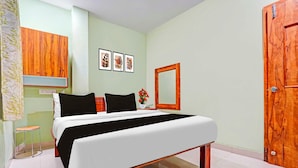 A bedroom with a bed, a wooden wardrobe, a mirror, and a door. - Collection O Dighori Nagpur (Nagpur)