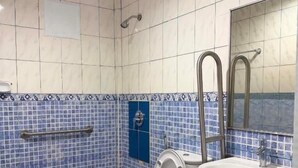 A bathroom with a toilet, sink, and shower. - We R Inn Hotel (Davao City)
