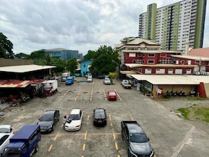 A parking lot with various vehicles, including cars and trucks, and buildings in the background.