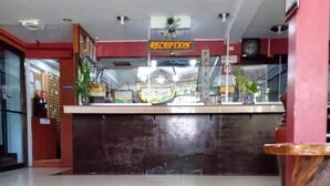 A reception area with a reception desk, a clock, and a sign indicating the reception.