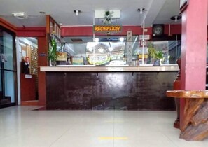 A reception area with a reception desk, a clock, and a sign indicating the reception.