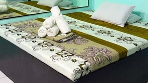 A hotel room with a bed, a small table, and a mirror. - We R Inn Hotel (Davao City)