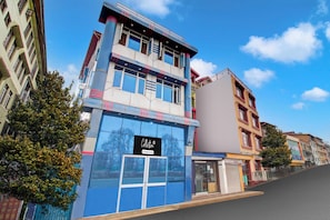 A multi-story building with a modern facade, large windows, and a sign indicating a company service. - Collection O Srinagar Jhelum Riverside (Srinagar)