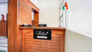 Un mostrador de recepción de madera con un cartel que indica que es un punto de recogida de servicios de empresa.