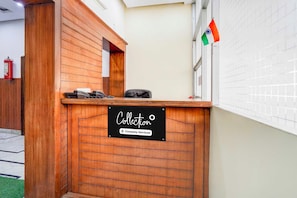 Un mostrador de recepción de madera con un cartel que indica que es un punto de recogida de servicios de empresa.