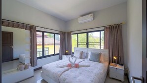Une chambre d’hôtel avec un lit, une table de chevet, un miroir, une armoire et une fenêtre avec des rideaux.