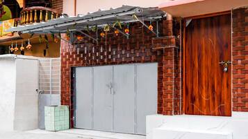 A building with a brick facade, a grey double door, and a wooden door.