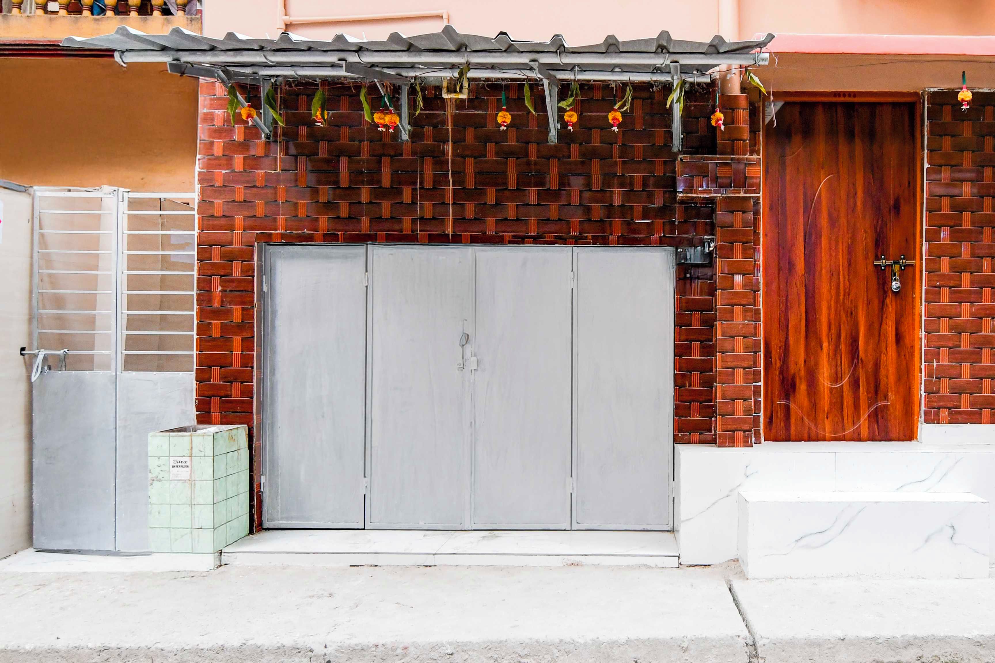 A building with a brick facade, a grey garage door, and a wooden door.