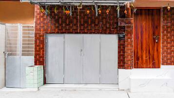 A building with a brick facade, a grey garage door, and a wooden door.