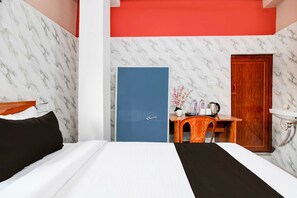 Ein Hotelzimmer mit Bett, Schreibtisch, Kleiderschrank und Bad.