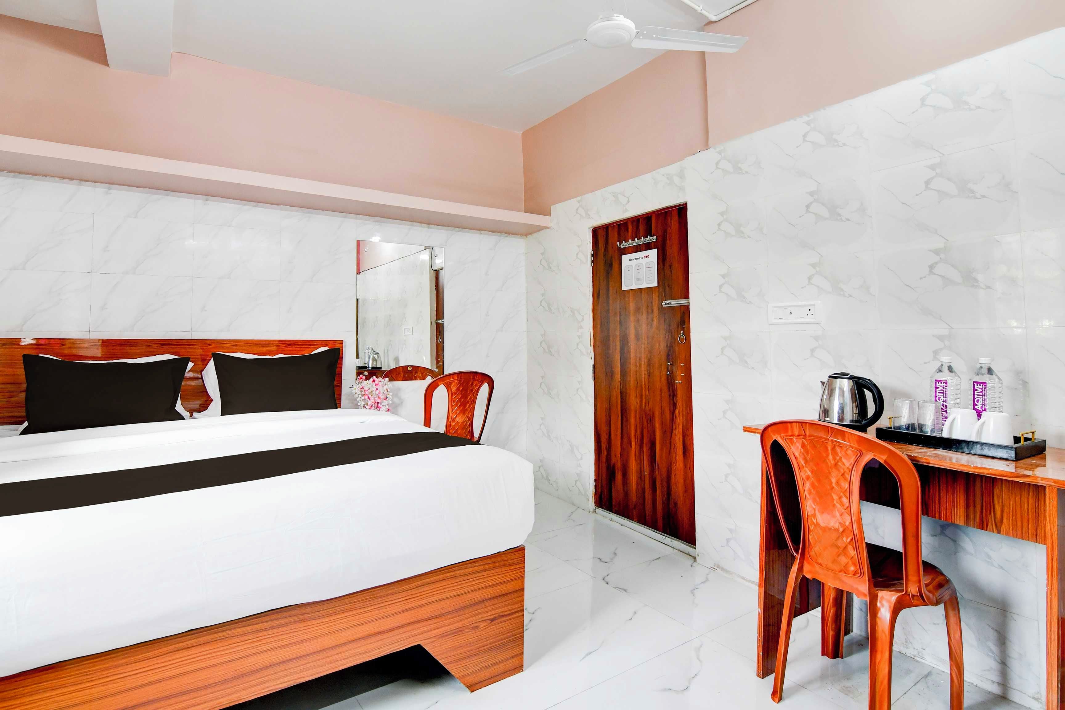 A hotel room with a bed, a desk, and a chair.