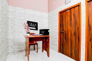 Una habitación con escritorio de madera, una impresora y un cartel que indica que es una habitación de servicio de la empresa.