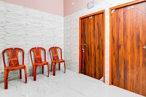 A room with three wooden chairs, two wooden doors, and a marble wall. - Collection O Kolkata Jadavpur University (Bidhannagar)