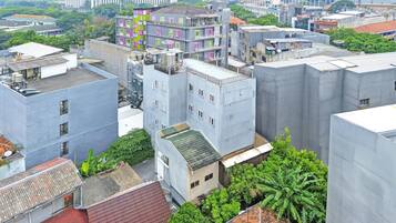 A multi-story building with a flat roof, surrounded by other buildings and greenery.