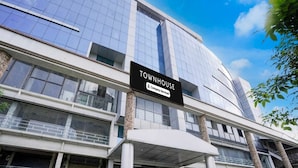Un immeuble moderne avec une enseigne indiquant : « TOWNHOUSE 5, services d’entreprise ».