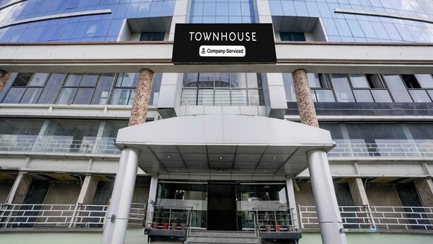 Un immeuble moderne avec une enseigne indiquant : « TOWNHOUSE, services d’entreprise ».