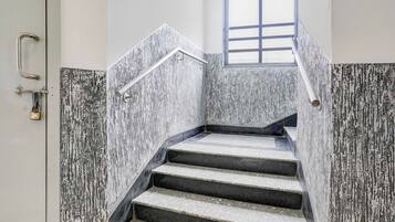A staircase with a metal handrail and a window at the top.
