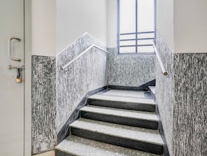 A staircase with a metal handrail and a window at the top. - Townhouse Bharuch Railway Station (Bharuch)