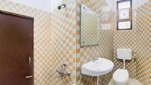 A bathroom with a checkered tile pattern, a white sink, a toilet, and a door. - Collection O Insaf Nagar Munshipuliya  (Lucknow)