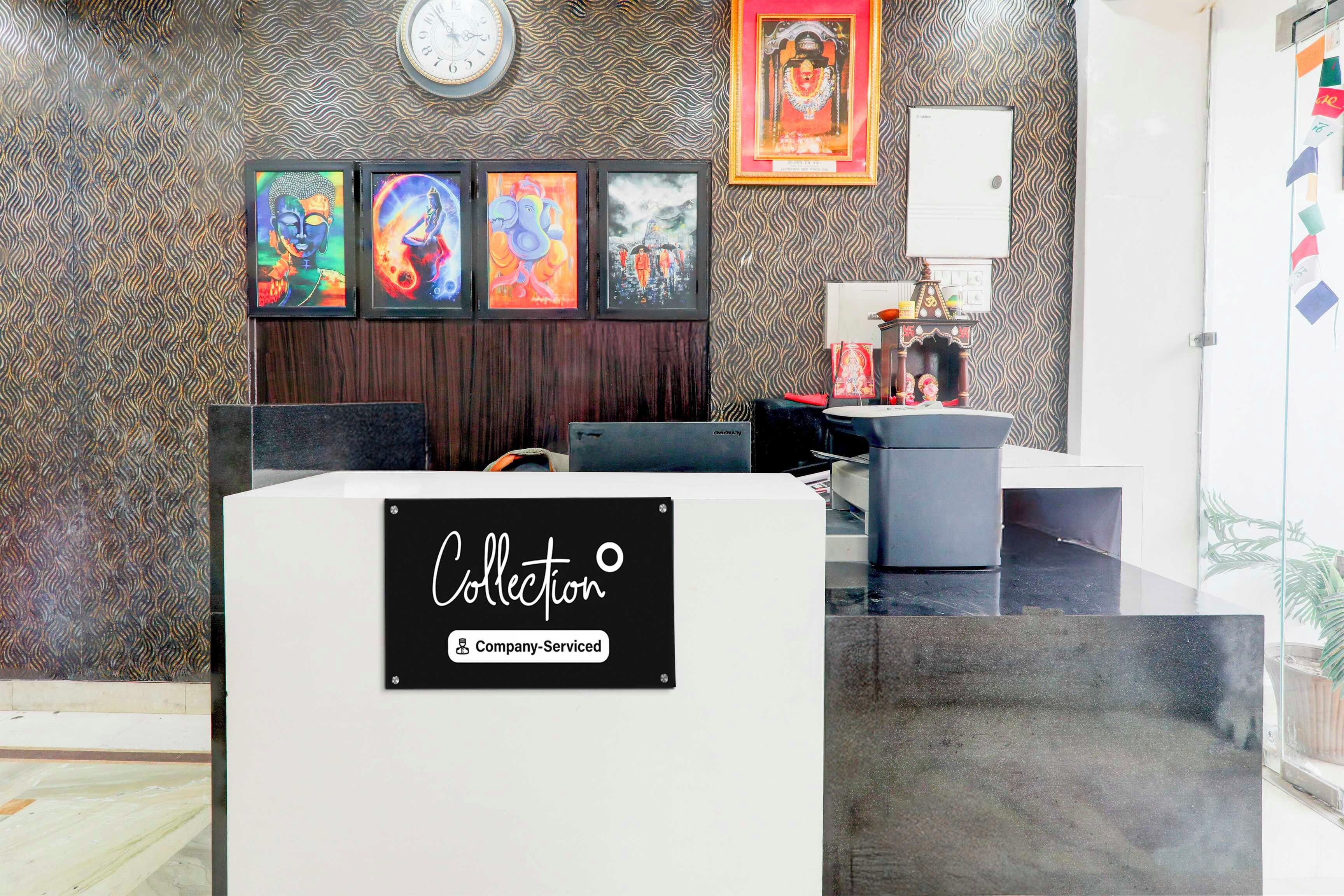 A reception area with a clock, framed artwork, a desk, and a sign indicating 'Collection' and 'Company-Serviced'.