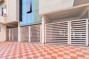 Un edificio con piso a cuadros, pared azul y portones blancos con listones horizontales.