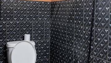 A bathroom with a shower, toilet, and sink.