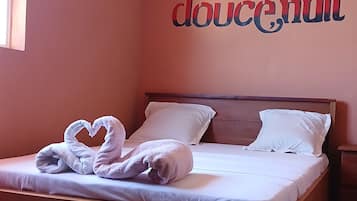 Une chambre à coucher avec un lit, des oreillers et un mur sur lequel est écrit le mot « doucenuit ».