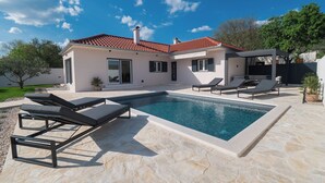 A modern house with a swimming pool, outdoor seating, and a garden. - Casa Mia with heated pool (Danilo Biranj)