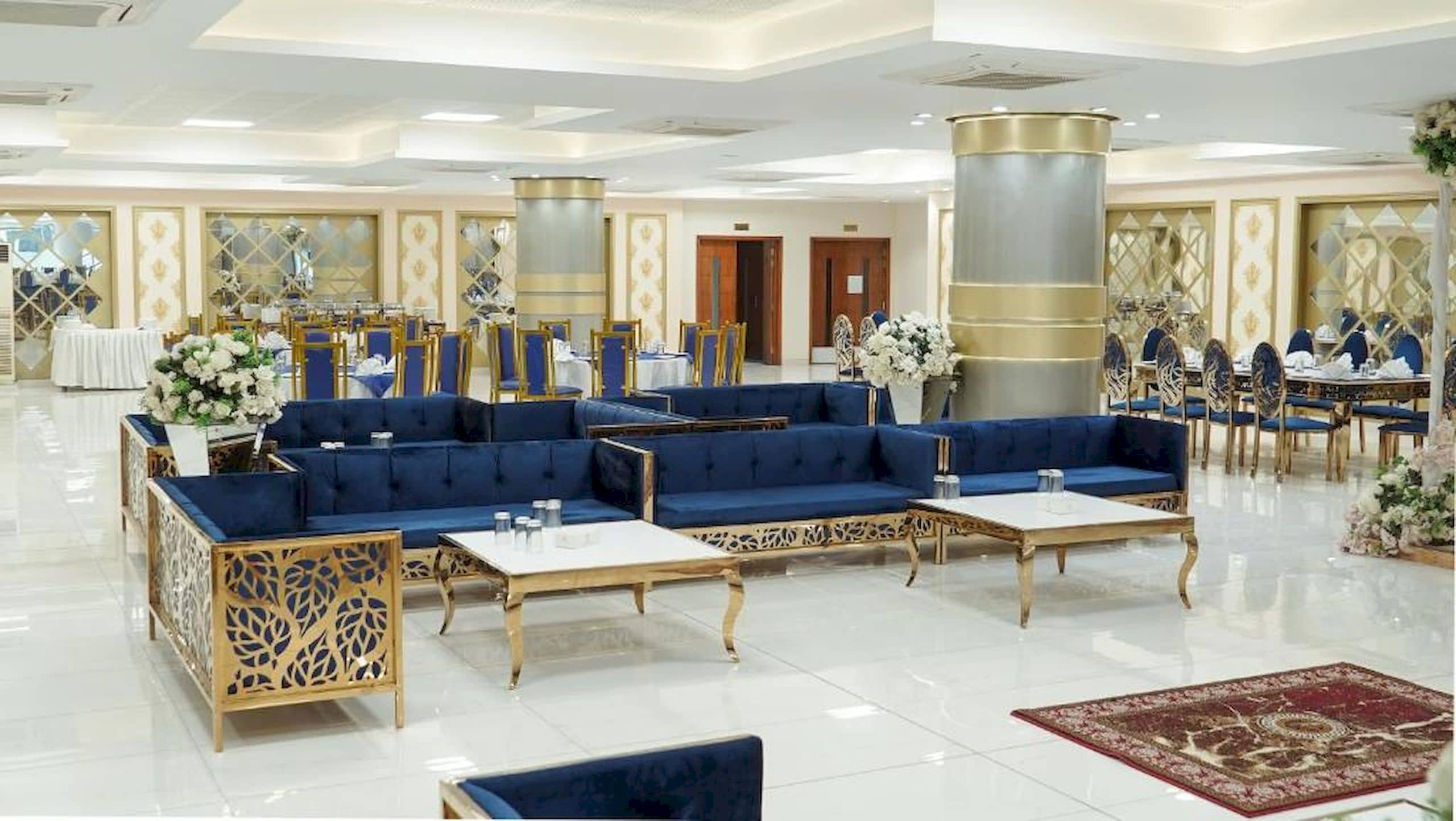 A spacious lobby with a seating area, tables, and decorative elements.