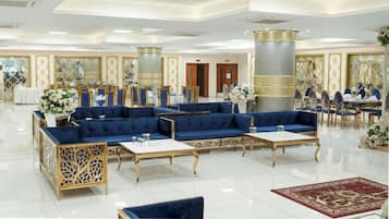 Un hall amplio con zona de estar, mesas y elementos decorativos.