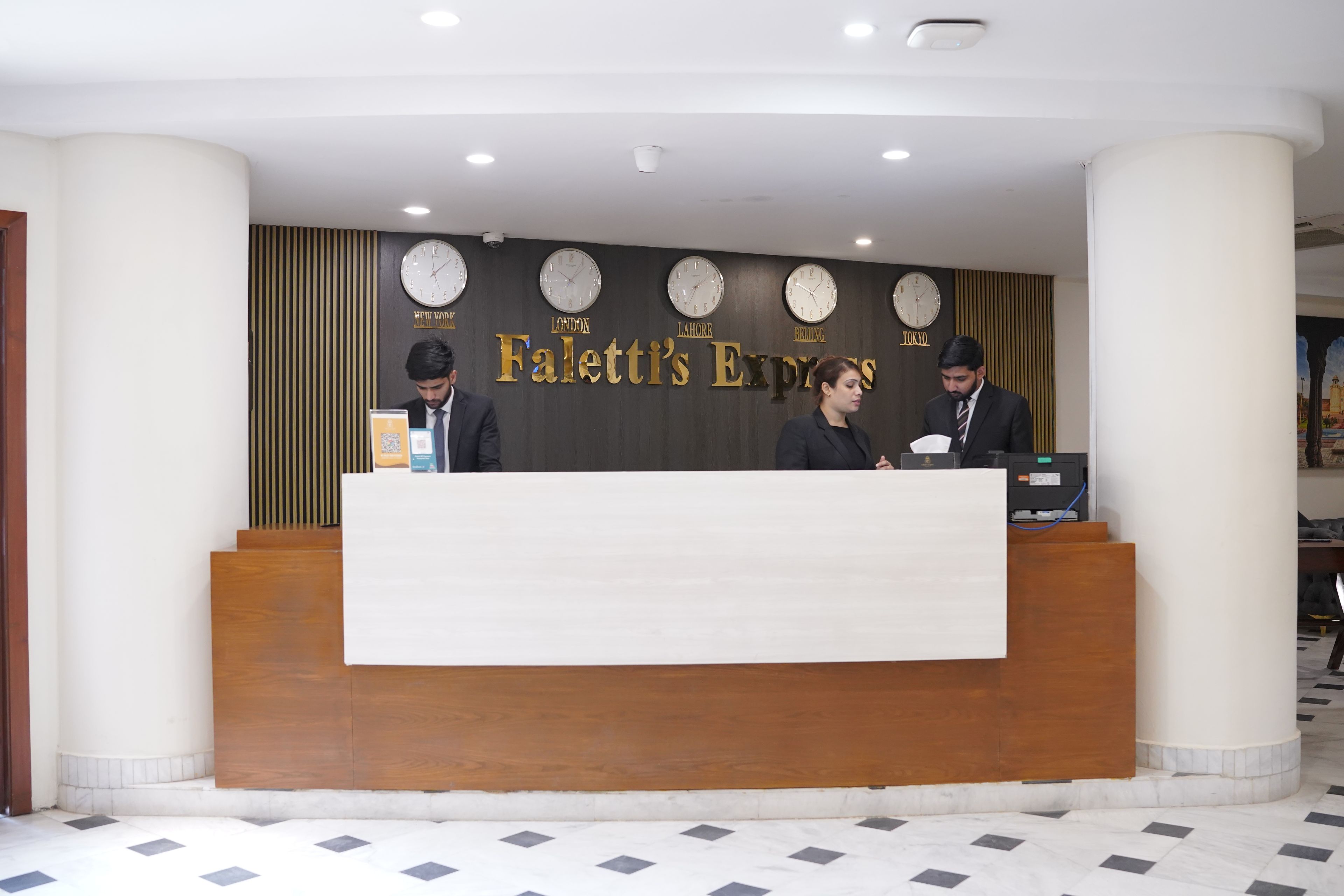 A reception desk with clocks displaying times from various cities, a sign reading 'Paletti's Express,' and a modern interior design.