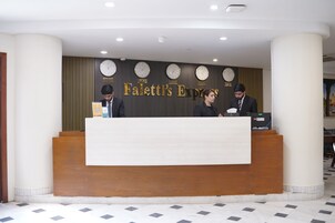 A reception desk with clocks displaying times from various cities, a sign reading 'Paletti's Express,' and a modern interior design.