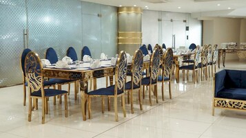A conference room with a long table and chairs, a sofa, and a decorative wall.