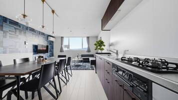 A modern kitchen with a dining area, a large window, and a view of the outdoors.
