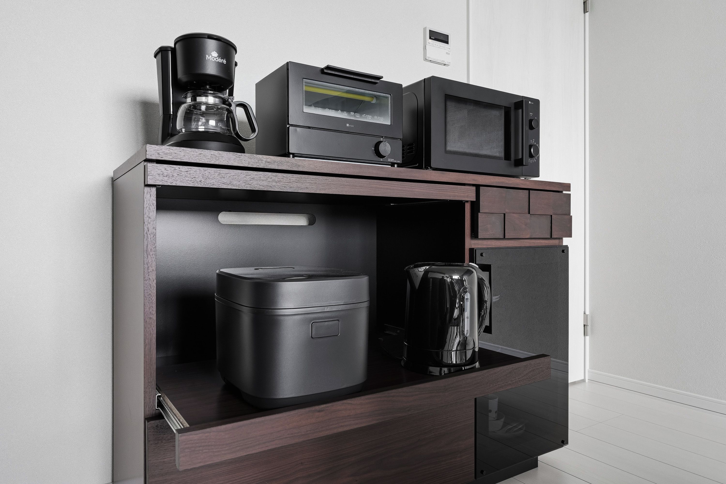 A compact kitchenette with a coffee maker, microwave, and a small refrigerator.