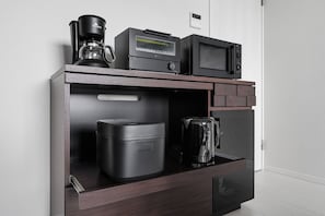 A compact kitchenette with a coffee maker, microwave, and a small refrigerator. - Snow (Furano)