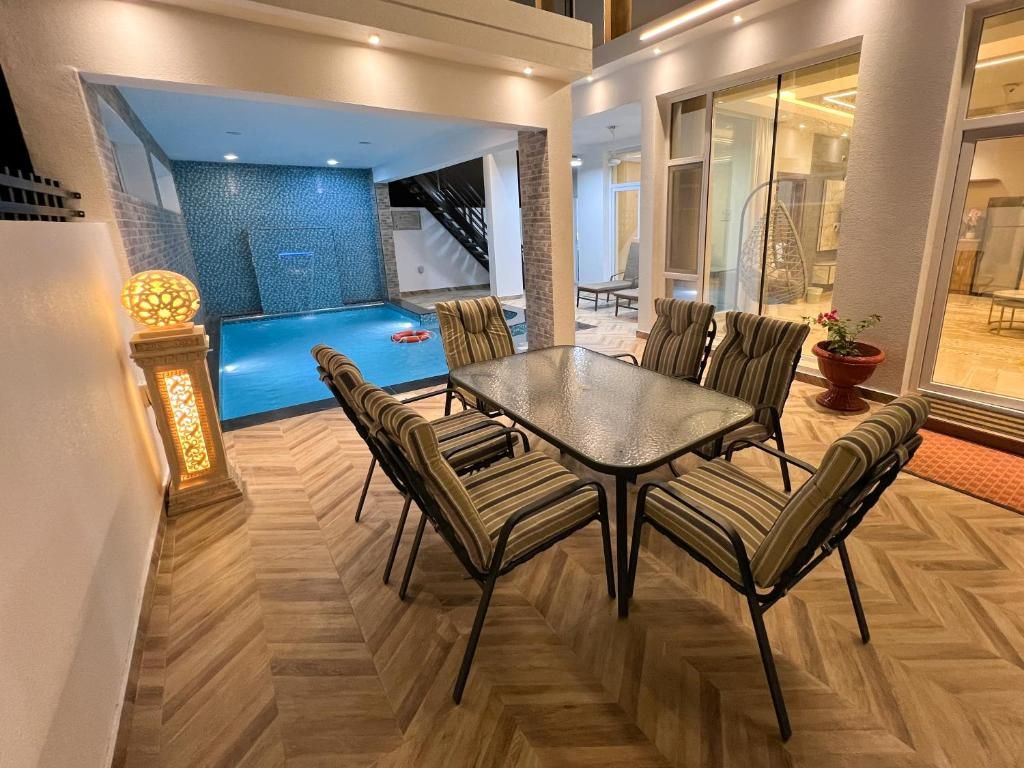 Un comedor con vista a la piscina, una escalera y un vidrio que da a un balcón.