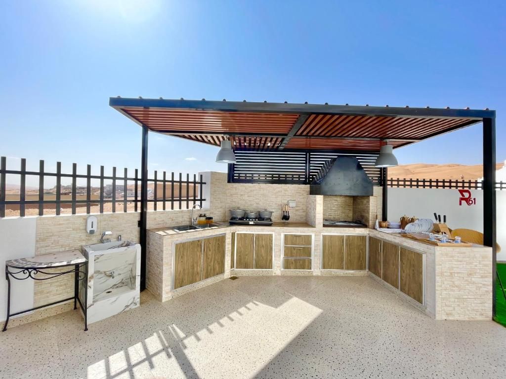 An outdoor kitchen with a pergola, a sink, and a stove.