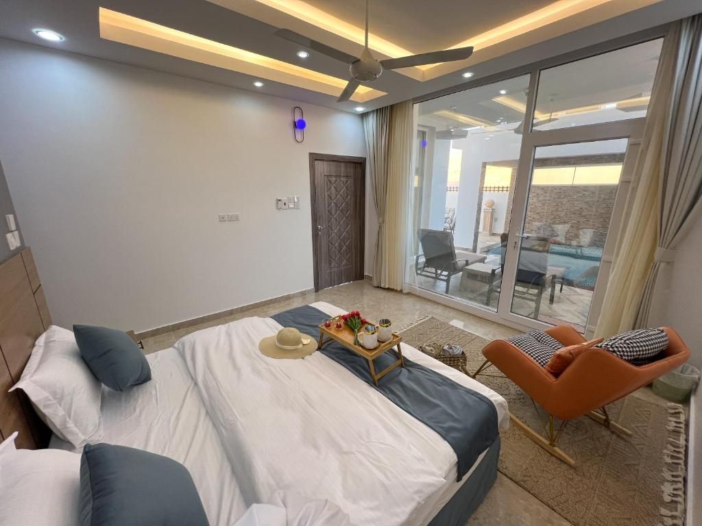 Een moderne slaapkamer met een groot bed, een zithoek en uitzicht op het landschap.
