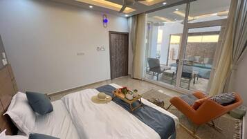 Une chambre moderne dotée d’un grand lit, d’un coin salon et offrant une vue sur l’extérieur.