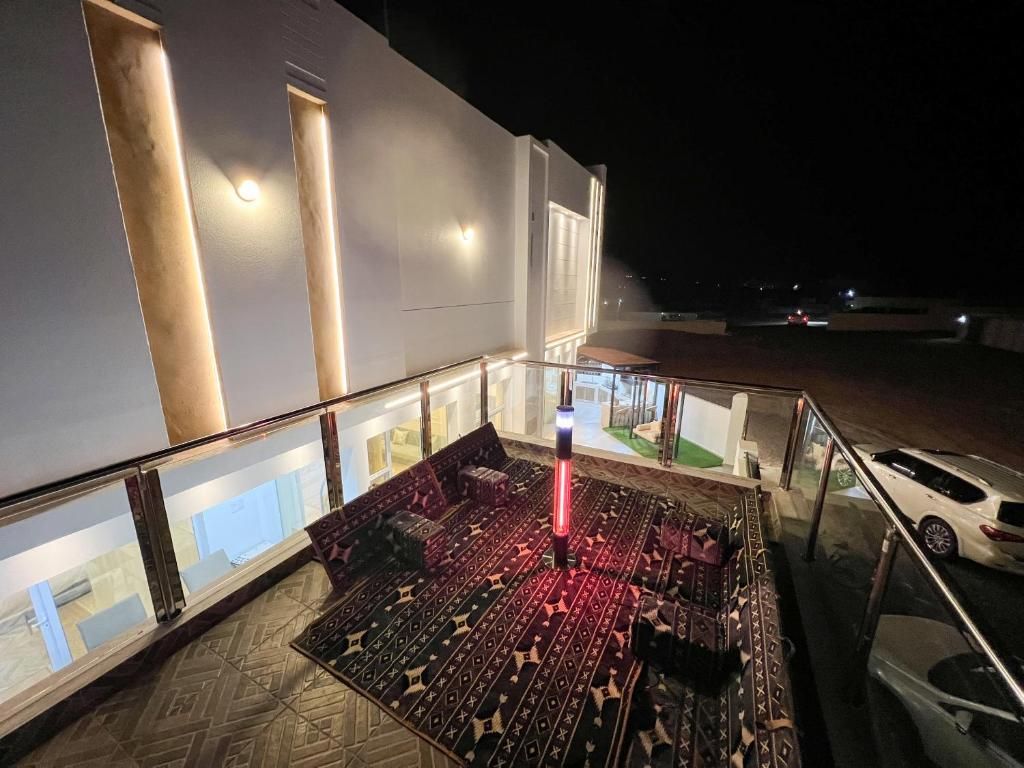 A rooftop terrace with a patterned floor, a railing, and a car parked nearby.