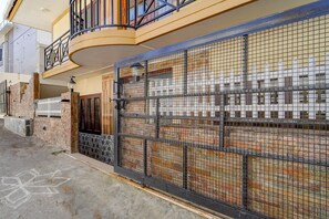 A residential building with a gated entrance, a balcony, and a brick facade. - Collection O Fairy Waterfalls (Kodaikanal)