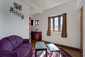 A living room with a purple sofa, a glass-top table, and a window with curtains. - Collection O Fairy Waterfalls (Kodaikanal)