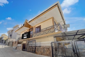 A two-story residential building with a balcony, a gated entrance, and a clear sky. - Collection O Fairy Waterfalls (Kodaikanal)