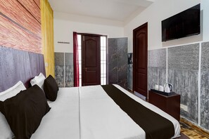 A hotel room with a bed, a TV, a wardrobe, and a bedside table with a kettle. - Collection O Fairy Waterfalls (Kodaikanal)