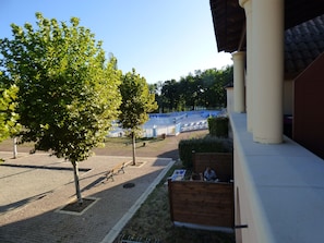 Ein Innenhof mit Pflasterfläche, Bänken und einer Umzäunung.
