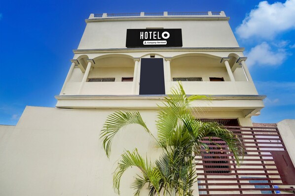 A hotel named 'HOTELO' with a sign indicating it is company-serviced.