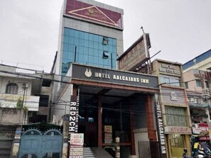 A hotel with a prominent sign, a modern facade, and a visible entrance.