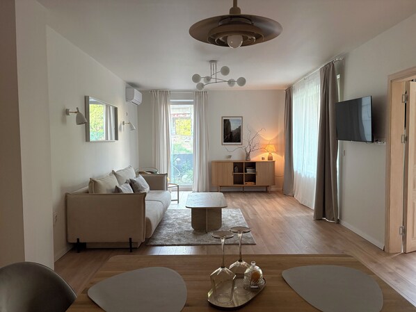A modern living room with a sofa, a coffee table, and a TV.